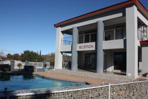 a building with a swimming pool in front of it at On Hill Lodge in Bloemfontein +10 photos