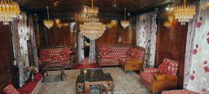 a living room with red furniture and chandeliers at Houseboat Green Mountain in Srinagar