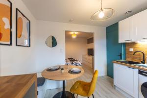 a kitchen and living room with a table and chairs at S1 SWEET HOMES Angoulême I Secteur Champs de Mars I Studio 2 couchages - Animaux acceptés in Angoulême +49 photos