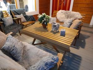 a living room with a wooden table and couches at Cozy cottage on lake in Iokela
