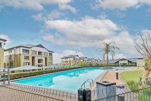 a large swimming pool with buildings in the background at Urban Waterfall Hideaway in Midrand