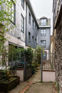a building with a gate and a courtyard with plants at La Mansarde Cauchoise - Centre ville - Au calme in Rouen
