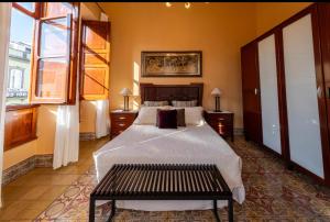 a bedroom with a bed and a bench in it at Triana modernista in Las Palmas de Gran Canaria