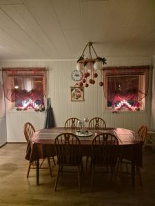 a dining room with a table and chairs and windows at Utsikten Feriehus i Bakkeby in Bakkeby +57 photos