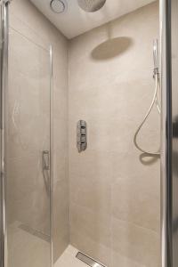 a bathroom with a shower with a glass door at Studio aan de gracht in Delft