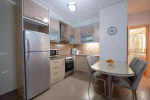 a kitchen with a table and a refrigerator at Cavo Paradise in Sarandë