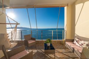 a balcony with a hammock and a view of the ocean at Cavo Paradise in Sarandë