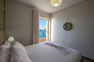 a bedroom with a bed with a mirror and a window at Cavo Paradise in Sarandë