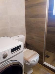 Un baño con inodoro y lavadora. en Nana's Luxury House, en Nafpaktos 1 foto más