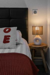 a bedroom with a bed and a lamp on a table at Residence Germot - Maison et Appartements design proche Thermes in Vichy