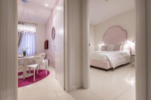 a white bedroom with a bed and a desk at Opera Relais De Charme - Aparthotel in Verona