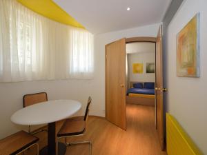a room with a table and a bedroom with a bed at Garden Studio Apartment Zürichberg in Zürich