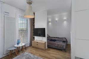 a bedroom with a bed and a table and a television at Soft Loft Legnicka in Wrocław