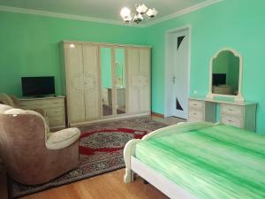 a bedroom with a bed and a chair and a mirror at Guest House Sirius in Chişinău