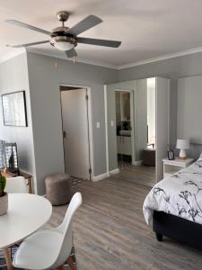 een slaapkamer met een bed en een plafondventilator bij Cozy Cottage in Kaapstad