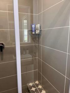 een badkamer met een douche met een glazen deur bij Cozy Cottage in Kaapstad +8 foto's