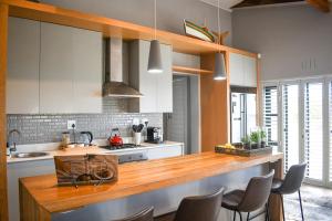 a kitchen with white cabinets and a wooden counter top at MOS-Palmiet 72 in Kleinmond