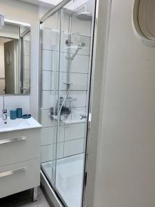 a bathroom with a glass shower and a sink at Spacieuse Maison Bleue, au centre des Cordiers in Le Tréport