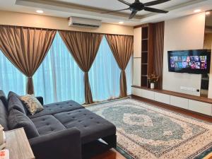 Hermosa Homestay في لاهاد داتو: غرفة معيشة مع أريكة وتلفزيون بشاشة مسطحة