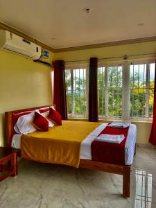 a bedroom with a large bed in a room with windows at Lakshmi Flower Tech Resort in Yelagiri +98 photos