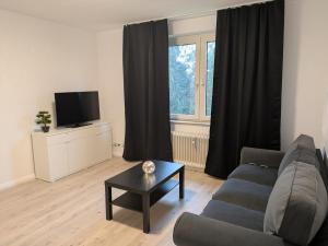 a living room with a couch and a table in front of a window at interaktiv Appartements in Heiligenhaus - Herzogstrasse in Heiligenhaus