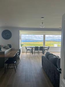 a living room with a couch and a table and chairs at Teach Susie Portnoo Accessible Holiday Home with Assistive Equipment in Portnoo
