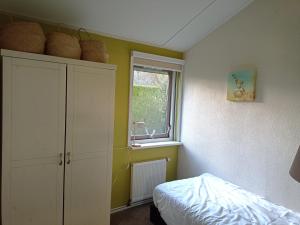 a bedroom with a bed and a window at Vakantiewoning met serre en airconditioning in Tzummarum +22 photos
