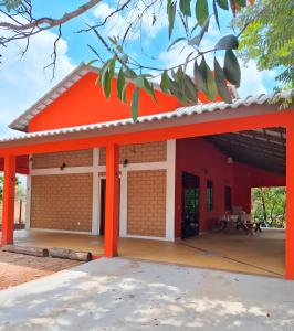 ein rotes Gebäude mit einem orangefarbenen Dach in der Unterkunft Casa Mirante da Serra in Cavalcante