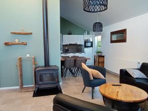 a living room with a fireplace and a stove at Vakantiewoning met serre en airconditioning in Tzummarum