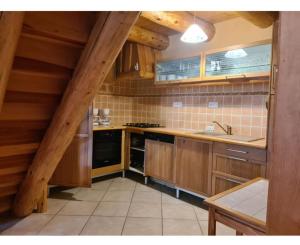 Una cocina con gabinetes de madera y un horno de estufa. en Gîte Les Bises, en Bronac