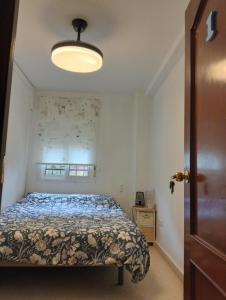 a bedroom with a bed with a blue comforter at Habitación 1 Piso Particular Castilleja de la Cuesta in Castilleja de la Cuesta