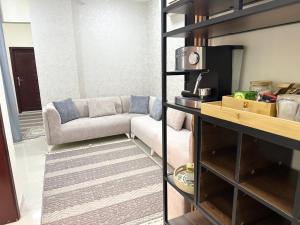 a living room with a couch and a table at شقق الغيث للإيجار in Al Khawḑ