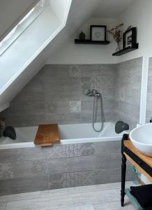 a bathroom with a bath tub and a sink at La Maison Mimosa - Espace, Confort et Proche Plage in Portbail