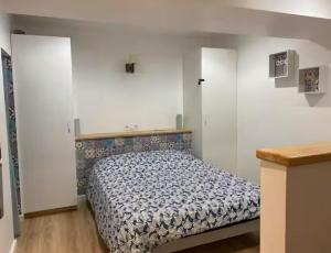 una camera da letto con un letto in una stanza bianca di Appartements du val a Vitré