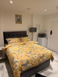 a bedroom with a bed with a yellow comforter at Luxury Studio in Victoria, 7 minutes walk to Victoria Station, Room 1 in London