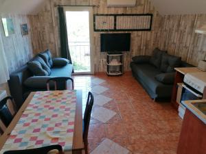 a living room with a couch and a table at Tabán Apartman in Dunakeszi