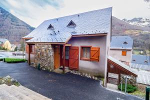 a house with red doors and a mountain at Chalet d'Estive in Cauterets