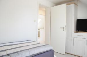 a bedroom with a bed and a flat screen tv at Ferienwohnung Anni in Schneverdingen +4 photos