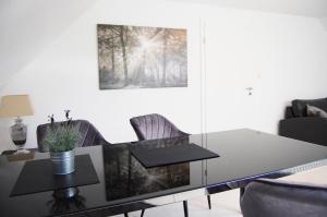 a dining room table with chairs and a glass table at Ferienwohnung Anni in Schneverdingen
