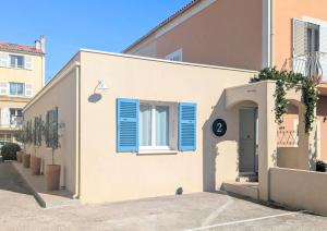 a building with blue shutters on the side of it at Hôtel Flor in Saint-Florent