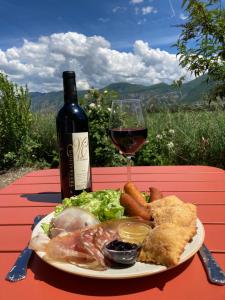 a plate of food and a glass of red wine at Chambre d'hôtes Les Calades in Lardier-et-Valença +31 photos