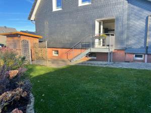 een huis met een balkon en een tuin bij Ferienwohnung Dellori in Winterberg +3 foto's