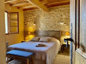 Mas des Olivades - Ferme Provençale - Piscine في بيرنيه لو فونتينز: غرفة نوم بسرير وجدار حجري +183 صورة