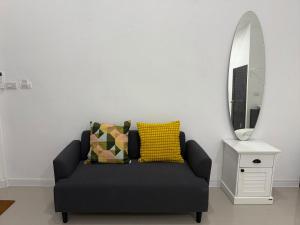 a black couch in a living room with a mirror at PMEs Home in Ban Wang Kanhuat