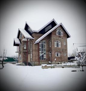 a large brick house with snow on it at Gulmarg Orchard in Gulmarg
