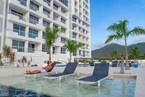 a man laying in a chair next to a pool at a hotel at Hotel porto horizonte suite 329 Santa Marta in Playa Bello Horizonte