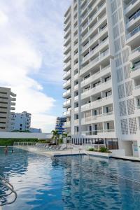 a swimming pool in front of two tall buildings at Hotel porto horizonte suite 329 Santa Marta in Playa Bello Horizonte