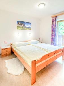 a large bed in a bedroom with a wooden frame at Ferienwohnung Haus Waldheim in Werfenweng