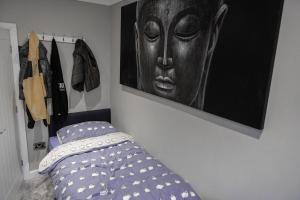 a bedroom with a bed and a picture of a head at The bungalow at Phoenix Court in Todmorden