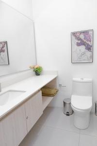 a white bathroom with a toilet and a sink at Hotel porto horizonte suite 329 Santa Marta in Playa Bello Horizonte